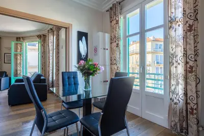 a salon with chairs and a table and a window at VICTOR HUGO - Modern and sunny, terrace, 2 baths in Nice