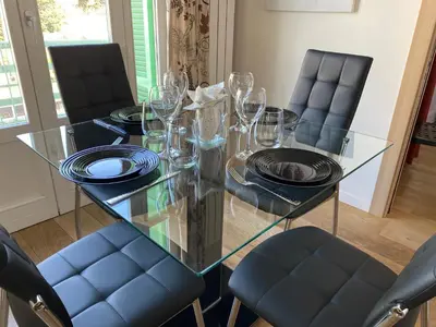 a glass dining table with chairs and plates and glasses at VICTOR HUGO - Modern and sunny, terrace, 2 baths in Nice