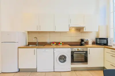 a kitchen with white cabinets and a washing machine at CARRE D'OR TERRACE AP4015 NICE by Riviera Holiday Homes in Nice