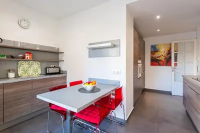 a kitchen with a white table and red chairs at Le Joffre Grimaldi Nice AP2089 in Nice