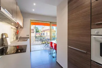 a kitchen and dining room with a view of a balcony at Le Joffre Grimaldi Nice AP2089 in Nice