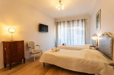 a bedroom with two beds and a dresser and a tv at Le Joffre Grimaldi Nice AP2089 in Nice
