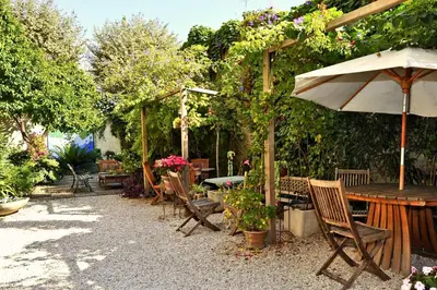 a room with two beds and a table and two windows at Nice Garden Hotel in Nice