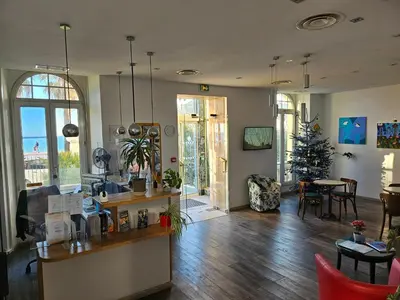 a living room with a kitchen and a christmas tree at Hotel Flots d'Azur Promenade des Anglais in Nice