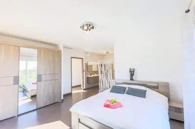 a bedroom with a large white bed and a kitchen at CORNICHE D'ARGENT - Nice in Nice