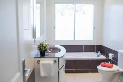 a bathroom with a tub and a toilet and a sink at Vinaigrier Hills VI3086 by Riviera Holiday Homes in Nice