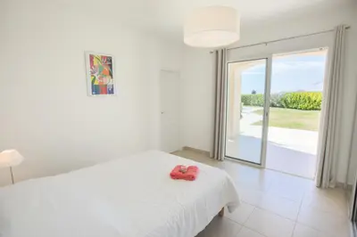 a white bed with a pair of red flip flops on it at Vinaigrier Hills VI3086 by Riviera Holiday Homes in Nice