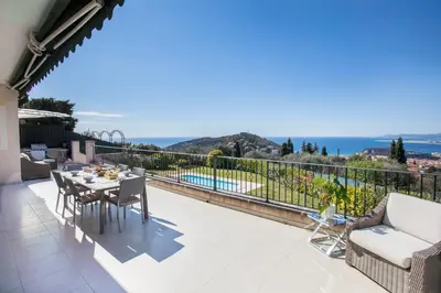 a patio with a table and chairs on a balcony at Vinaigrier Hills VI3086 by Riviera Holiday Homes in Nice