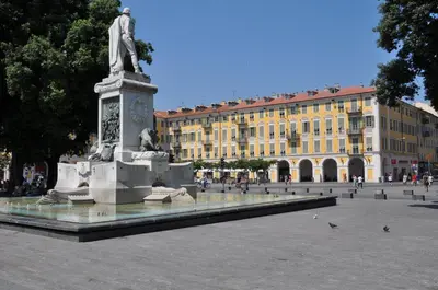 a statue in the middle of a plaza with a building at Charmant studio tout proche du port in Nice
