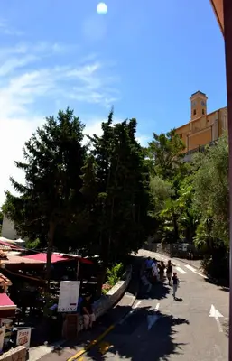 a group of people sitting on the side of a street at Hotel Arc En Ciel in Èze
