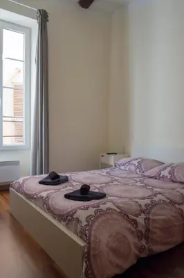 a bedroom with a bed with two hats on it at Magnifiques Appartements au coeur du Vieux Nice in Nice