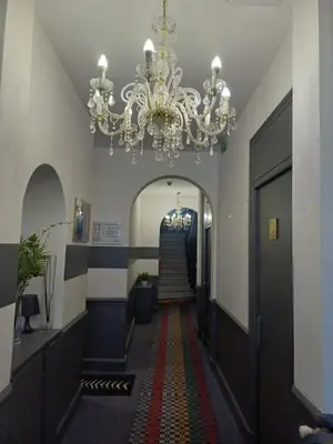 a hallway with a chandelier and a staircase at Little Palace in Nice