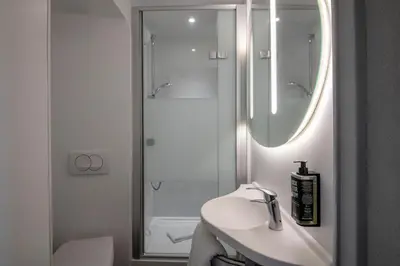 a white bathroom with a sink and a shower at ibis budget Nice Aeroport in Nice