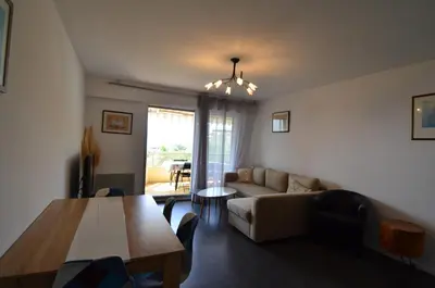a living room with a couch and a table at PLEIN CIEL - Appartement 5 personnes avec piscine sur la Corniche Fleurie à Nice in Nice