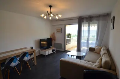 a living room with a couch and a tv at PLEIN CIEL - Appartement 5 personnes avec piscine sur la Corniche Fleurie à Nice in Nice