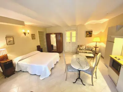 a bedroom with a bed and a table and a couch at Résidence La Villa Léonie in Nice