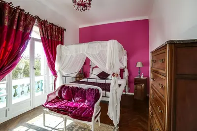 a bedroom with purple walls and a bed with a canopy at Villa Dracoena in Nice