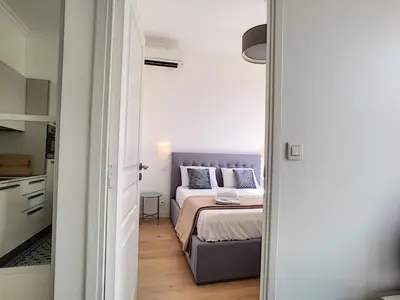 a small bedroom with a bed and a kitchen at Nestor&Jeeves - CAESARS - Hyper center - Shopping avenue in Nice