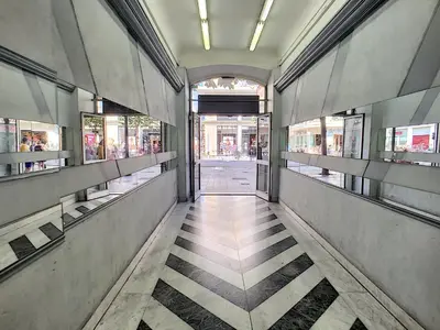 an empty hallway of a building with windows and a sidewalk at Nestor&Jeeves - CAESARS - Hyper center - Shopping avenue in Nice