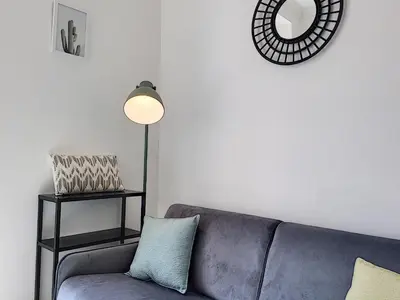 a living room with a blue couch and a lamp at Nestor&Jeeves - CAESARS - Hyper center - Shopping avenue in Nice