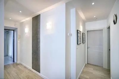 an empty hallway with white walls and wood floors at 
