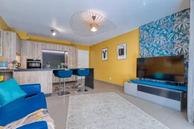 a living room with a blue couch and a large tv at Residence Blue Harmony in Nice