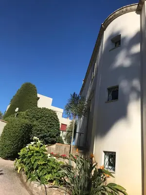 a white building with some plants next to it at 