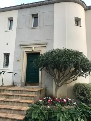 a building with a green door and a tree at 