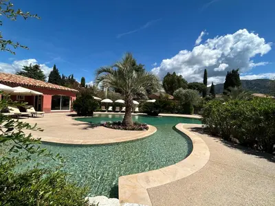 a swimming pool in a resort with a palm tree at Domaine De Respelido in Carros