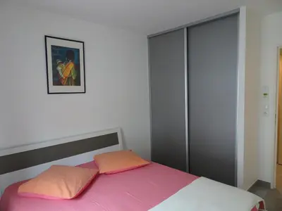 a bedroom with a bed with pink and orange pillows at Promenade Gambetta in Nice