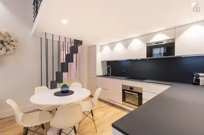 a kitchen and dining room with a white table and chairs at COURS SALEYA Renovated 3 Bedrooms 1 min to Beach Air Conditioning in Nice