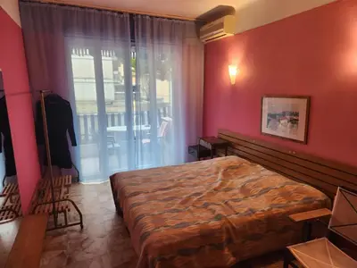 a bedroom with a large bed and a window at Big apart 140m2 5min walk to beach sea &Promenade 3 double rooms,big living room 42m2, 3 showers,9 beds, free parking in Nice