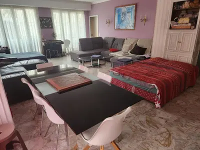 a living room with a table and a couch at Big apart 140m2 5min walk to beach sea &Promenade 3 double rooms,big living room 42m2, 3 showers,9 beds, free parking in Nice