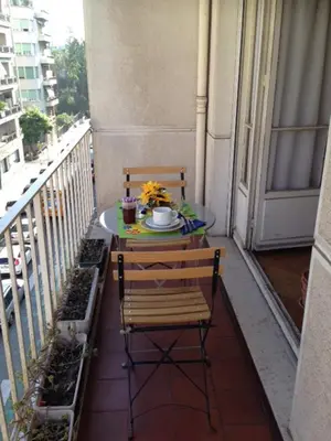 a table and a chair on a balcony at Le Catinat in Nice