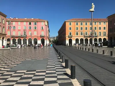 a city street with buildings and a statue in the middle at Rigoletto Massena in Nice