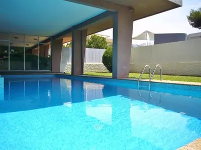a large blue swimming pool in front of a house at Le lutin in Saint-Laurent-du-Var