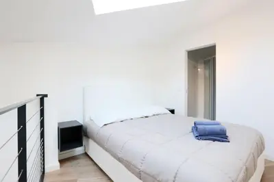 a bedroom with a white bed with a blue towel on it at Patio Wilson in Nice