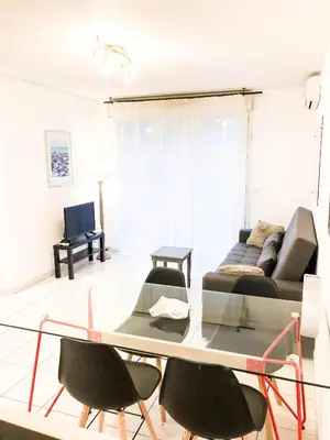 a living room with a couch and a table and chairs at Portobello residence in Nice