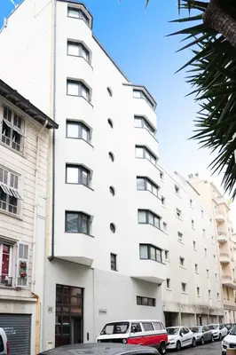 a white building with cars parked in front of it at Suite Relax Five Stars Holiday House in Nice