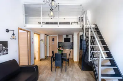 a staircase leading up to a living room and a dining room at JEAN MÉDECIN - Modern Flat - Heart of center in Nice