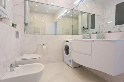 a white bathroom with a washing machine in it at Le Charme-35 in Nice