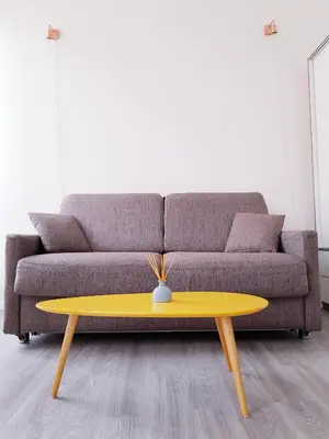 a living room with a couch and a yellow coffee table at Cosy central studio Nice Rossini large balcony in Nice