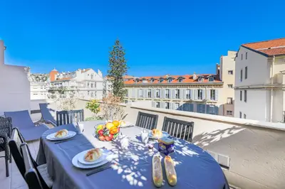 a table with a blue table cloth on a balcony at Palais l'Escurial AP4069 by Riviera Holiday Homes in Nice