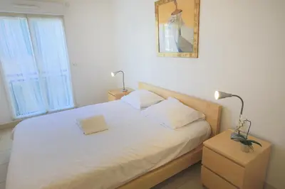 a bed with white sheets and pillows in a bedroom at PALAIS LIBERTE in Nice