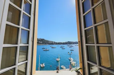 a view of a harbor through an open window at Quai des Marinières AP2015 by Riviera Holiday Homes in Villefranche-sur-Mer