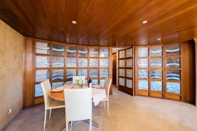 a dining room with a table and chairs and windows at Quai des Marinières AP2015 by Riviera Holiday Homes in Villefranche-sur-Mer
