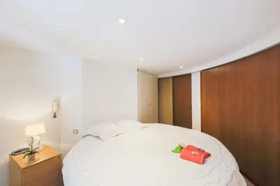 a bedroom with a white bed with a red box on it at Quai des Marinières AP2015 by Riviera Holiday Homes in Villefranche-sur-Mer