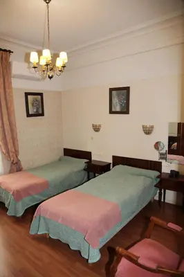 a bedroom with two beds and a chandelier at Hotel Cronstadt in Nice