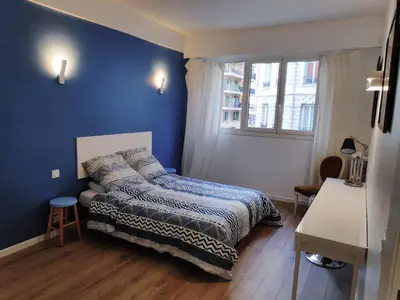 a bedroom with a bed and a blue wall at Best Apart - Nice Port - Balcony in Nice