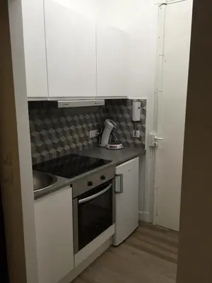 a small kitchen with white cabinets and a sink at STUDIO DECO DESIGN, HYPER CALME in Nice